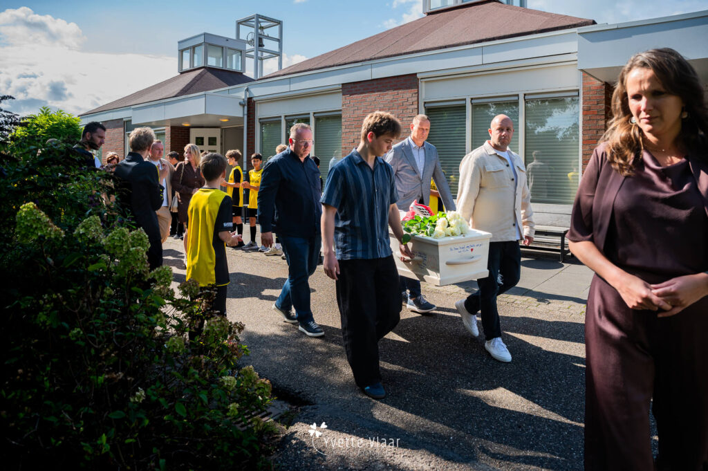 Het wegdragen van de kist van een kind door een erehaag